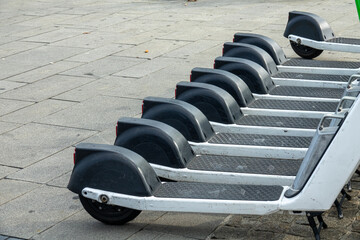 Row of electric scooters for public share. Electric urban transportation