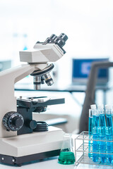 Medical Research Lab Interior with Microscope, close up shot modern medical research laboratory, prominent microscope, neatly arranged test tubes, highlighting pursuit of groundbreaking discoveries.