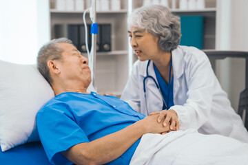 Senior elderly male patient and asian people mature woman doctor, showcasing importance of healthcare expertise and patient support. caring senior doctor assisting elderly patient in hospital bed