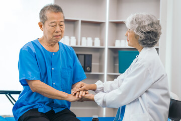 Obraz premium Senior elderly male patient and asian people mature woman doctor, showcasing importance of healthcare expertise and patient support. caring senior doctor assisting elderly patient in hospital bed