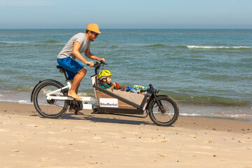 Papa und Kind haben Spaß mit dem Lastenrad am Strand,Skagen,Dänemark