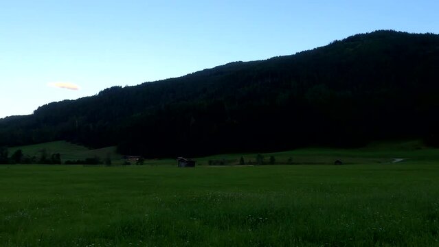 Mountains in Austria at the Brenner Pass at dusk with meadows and forests in 4k