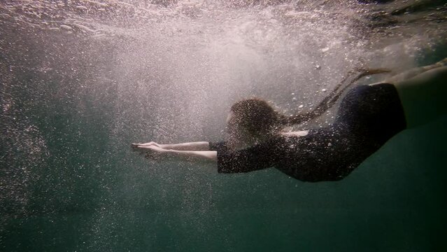 woman diving in swimming pool, underwater slow motion shot, female swimmer in water