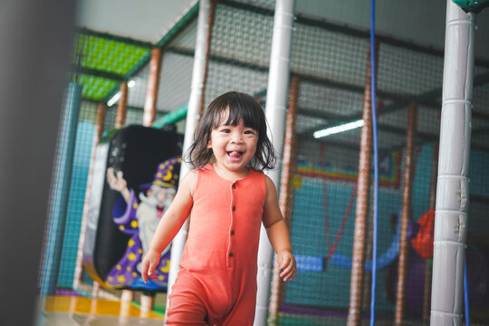 Action of a cute baby girl is playing at children playground place in happiness moment. People portrait photo with recreation activity.