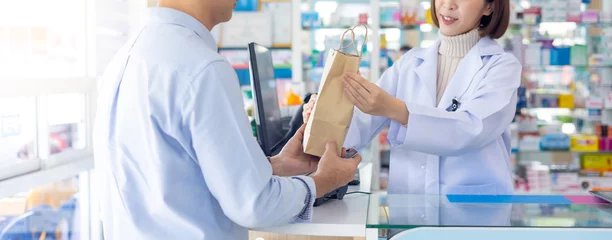 Rolgordijnen asian thai engineer construction worker customer buy Medication and pharmacist give recycle paper bag at Pharmacy medical shop and drugstore medication. Pharma Store Health Care Products © NVB Stocker