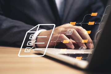 Businessman using laptop computer and touching to online electronic paper for approve ISO quality...