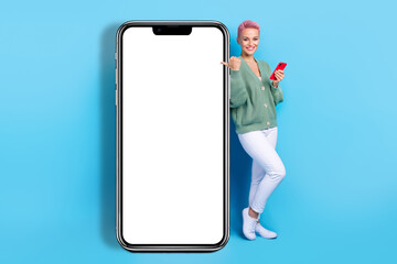Fototapeta na wymiar Full body length photo of young satisfied blogger girl point finger board display website discount offers isolated on blue color background