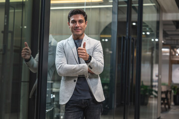 Caucasian male businessman, marketing executive, confident and working professional standing with thumbs up ready to serve in front of conference room.