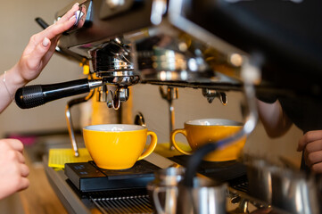 Fototapeta na wymiar woman hand making cappuccino on coffee machine to cup in bar