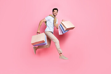 Full size profile photo of crazy excited person hold mall bags jump rush empty space isolated on...
