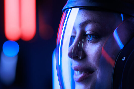 Astronaut in futuristic costume. Girl in glasses of virtual reality while touching air. Augmented reality game, future technology, AI concept. Dark background.