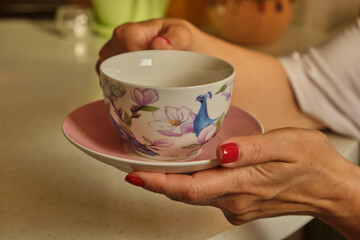 Woman pouring hot coffee in cup in the morning from pot. Housewife at home making fresh ground coffee in kitchen for breakfast, before going to work