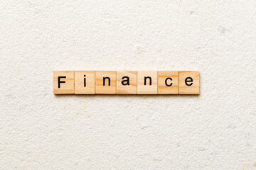 FINANCE word written on wood block. FINANCE text on cement table for your desing, concept