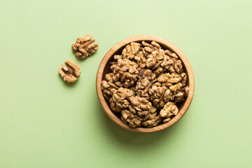 Fresh healthy walnuts in bowl on colored table background. Top view Healthy eating bertholletia concept. Super foods