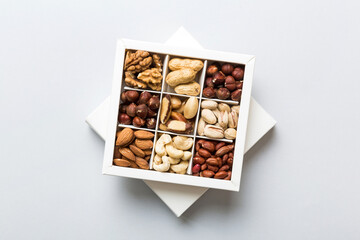 Various varieties of nuts lying in paper box on table background. Top view. Healthy food. Close up, copy space, top view, flat lay. Walnut, pistachios, almonds, hazelnuts and cashews