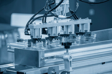 The plastic jar container part gripping by  vacuum robotic system in the conveyer belt.