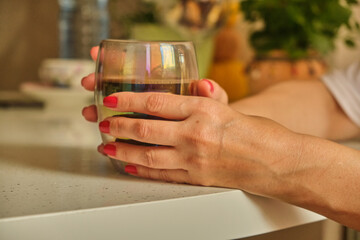 Woman pouring hot coffee in cup in the morning from pot. Housewife at home making fresh ground coffee in kitchen for breakfast, before going to work