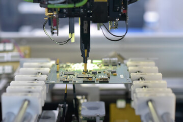 robot automatically assembles circuit board with electronic components in a modern factory - 649342890