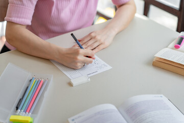 Asian girl student doing exam hand holding pencil writing answer in university classroom education high school or university student taking notes while preparing for exam