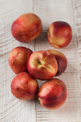 Juicy ripe nectarines on a white wooden background. Healthy eating, fruits.