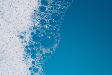 Detergent foam bubble on water. Blue background, Soap sud