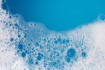 Detergent foam bubble on water. Blue background, Soap sud