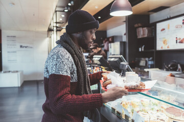 Young black man indoor bar holding tray - break, free time, recreation concept