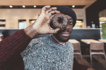 young beautiful black man indoor bar playing donuts
