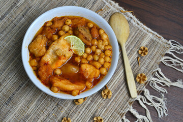 top view flat lay Aci Cuanki Meat Balls Soup or Baso Aci Cuanki, Indonesia Popular Street Food from Bandung with wooden spoon on textured background