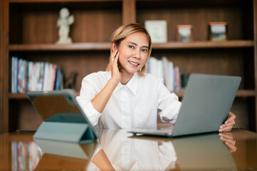 Asian woman working laptop. Shot of an attractive mature businesswoman working on laptop in her workstation Asian woman working laptop. Business woman busy working on laptop computer at office