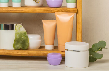 Skin care stage for healthy skin - face serum and lotion, scrub, peeling and cleanser on white wooden background. The concept of beauty and cosmetics. A set of cosmetics on a wooden shelf