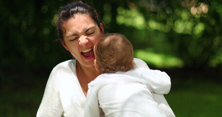 Fototapeta premium Mother and baby together outside in nature. Playful mom and infant