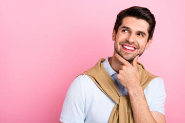 Portrait of satisfied creative young man arm touch chin beaming smile look interested empty space...