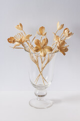 A glass vase with a bouquet of flowers made from straw on a white background