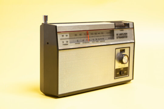 Vintage transistor radio, on yellow background.