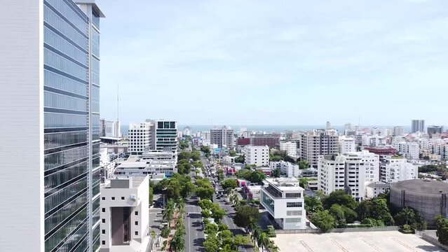 Drone vuelan por encima de la calle entre edificios modernos de altura con fachadas de color. 