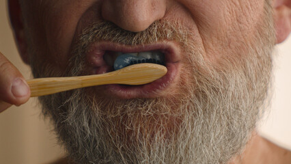 Close up unrecognizable old male retired middle-aged senior mature elderly man cropped view mouth brushing teeth toothbrush and toothpaste morning hygiene procedure oral anti cavity tooth care dental