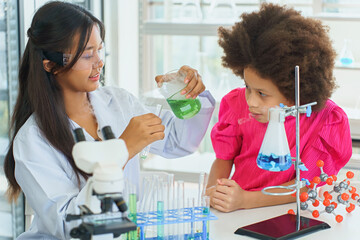 School children doing science experiments in school lab, children experimenting with mixing chemicals, learning experiments, scientists in laboratory, children's chemistry experiment in school lab.
