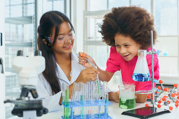 School children doing science experiments in school lab, children experimenting with mixing...
