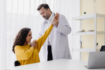 Senior professional physiotherapist doctor checking woman patient arm shoulder pain physical...