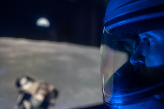 Space female astronaut greets and watching the landing on the moon. 