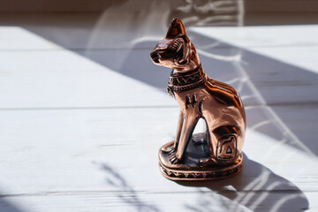 Egyptian cat statuette on white table.