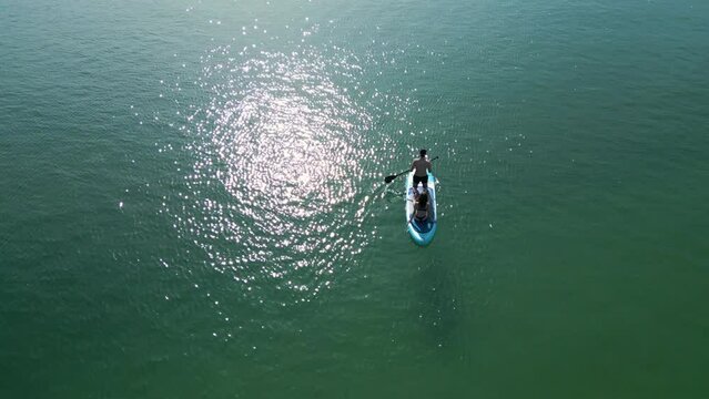 Traveling Couple On A Paddleboard On Water Surface In Aldan, Spain. aerial