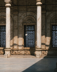 Interior of the courtyard of the Glass Mosque in the ancient city of Cairo, Egypt. Courtyard without people or tourists, with the porticos, windows, lamps and the fountain. Zooming shot. - obrazy, fototapety, plakaty