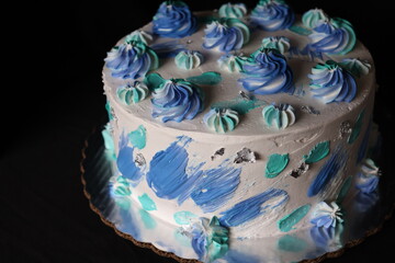Stand with beautiful tasty birthday blue cake on table against black background