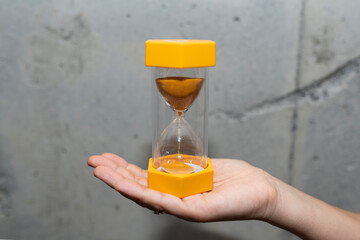 woman's hands holding an hourglass. time concept