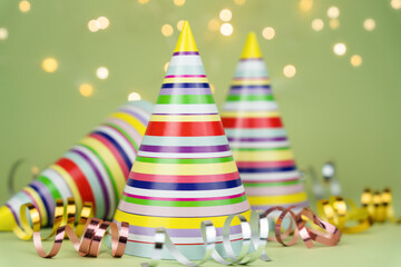 Colored party hats for holiday party on green background. Copy space. Close-up.