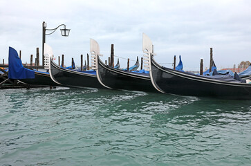 gondolas moored in the Venetian lagoon in Venice with no tourists