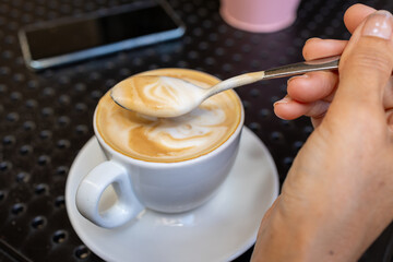 Steaming cup of creamy latte in ceramic mug