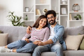 Fototapeta na wymiar Cute hindu millennial couple sitting on couch at home
